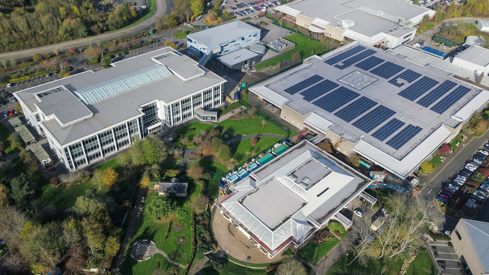Luftaufnahme von Gewerbegebäuden, eines mit Solaranlage auf dem Dach